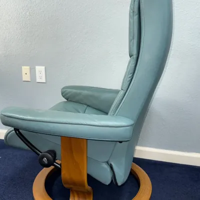 Sale Photo Thumbnail #231: Ekornes Stressless reclining armchair in teal blue leather, featuring a bentwood ring base and side adjustment knob.