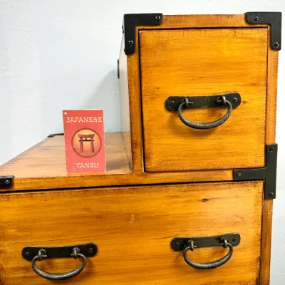 Sale Photo Thumbnail #203: Japanese tansu-style stepped wooden chest with decorative black iron hardware brackets and bale handles.