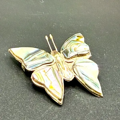 Sale Photo Thumbnail #186: Vintage abalone shell and sterling silver butterfly brooch featuring iridescent inlaid wings.