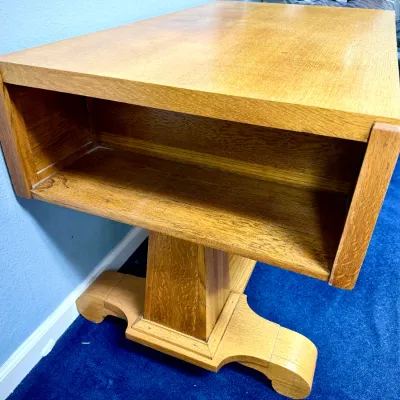 Sale Photo Thumbnail #682: Arts and Crafts style oak pedestal side table featuring an open lower storage cubby and carved feet.