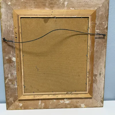 Sale Photo Thumbnail #158: Back of a framed canvas or panel artwork showing hanging wire, wooden stretcher frame, and hand-written inscriptions.