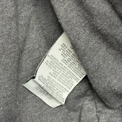 Sale Photo Thumbnail #883: Close-up detail of a garment fabric care and material composition tag inside a gray jacket lining.