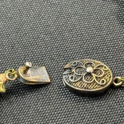Sale Photo Thumbnail #362: Vintage silver filigree box clasp on a knotted jade bead necklace, showing minor tarnish and wear.