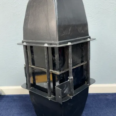 Sale Photo Thumbnail #542: Vintage black metal railroad or traffic signal light housing, featuring a protective cage design around the central body and mounting brackets.