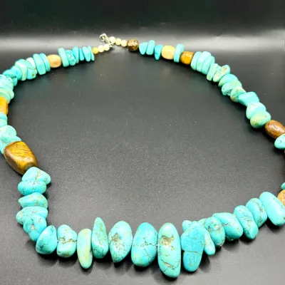 Sale Photo Thumbnail #349: Southwestern-style beaded necklace featuring turquoise nugget chips interspersed with tiger's eye and yellow accent stones, finished with a silver-tone lobster claw clasp.