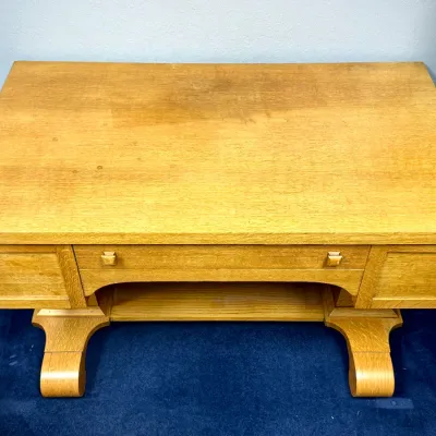 Sale Photo Thumbnail #681: Antique oak library desk or table featuring a wide top, lower storage shelf, and distinctive curved scroll feet.