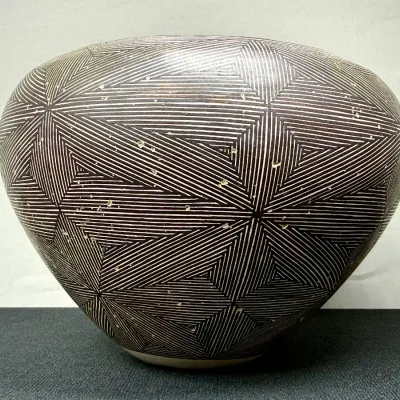 Sale Photo Thumbnail #3: Acoma Pueblo ceramic pot featuring intricate black-and-white fine line geometric starburst patterns. Showing light wear and surface marks consistent with handmade Native American pottery.