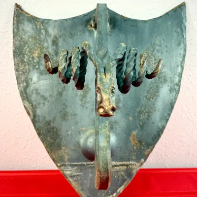 Sale Photo Thumbnail #411: Vintage wrought iron ram or goat head wall sconce mounted on a shield-shaped backplate with aged verdigris finish.