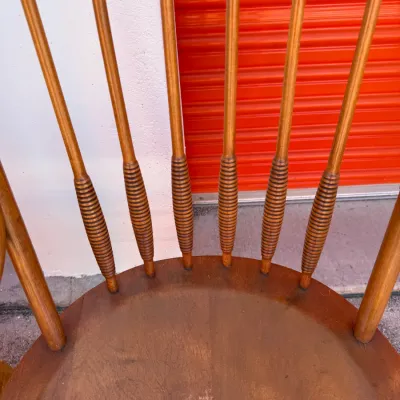 Sale Photo Thumbnail #706: Vintage Windsor-style wooden chair featuring turned spindles with reeded detailing and a saddle seat.