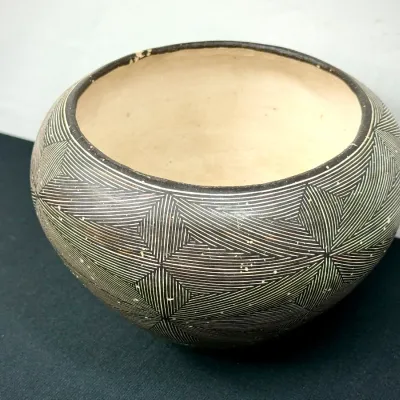Sale Photo Thumbnail #130: Handcrafted Southwestern style ceramic bowl featuring a dark exterior etched with intricate fine-line geometric geometric starburst patterns and a plain light-colored interior.