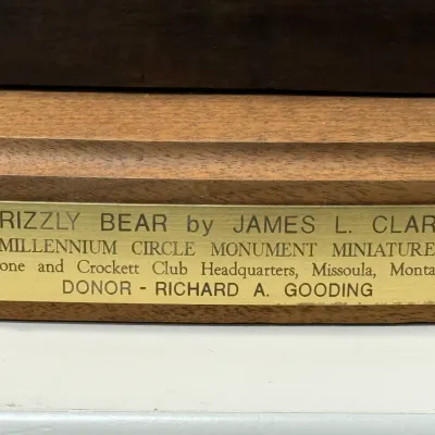 Sale Photo Thumbnail #124: Brass presentation plaque on a wooden base for a "Grizzly Bear" miniature monument sculpture by James L. Clark.