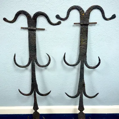 Sale Photo Thumbnail #639: Pair of antique hand-hammered wrought iron wall racks or hooks featuring scrollwork design and rustic aged finish.