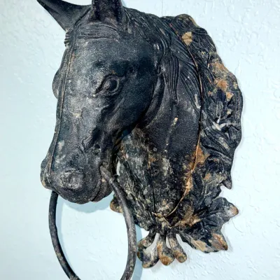 Sale Photo Thumbnail #647: Vintage cast iron horse head hitching post topper or wall mount with a metal ring, featuring an aged, weathered dark patina.