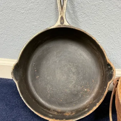 Sale Photo Thumbnail #587: Vintage nickel-plated cast iron skillet with dual pour spouts and front helper handle, showing surface wear and patina.