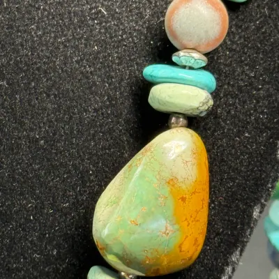 Sale Photo Thumbnail #340: Close-up of a Southwest-style beaded necklace featuring turquoise, agate, and various gemstone beads separated by silver accents.