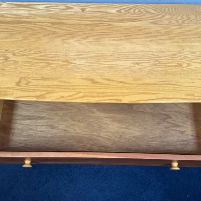 Sale Photo Thumbnail #720: Top-down view of a light oak wooden dresser showing an open top drawer with wood knobs and a visible maker's mark.
