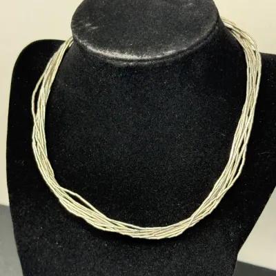 Sale Photo Thumbnail #179: Multi-strand liquid silver liquid beads necklace displayed on a black velvet jewelry bust, showcasing a delicate Southwestern design.