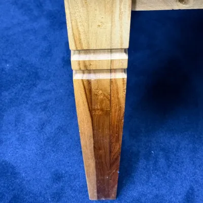Sale Photo Thumbnail #738: Close-up detail of a tapered light wood table leg with subtle decorative carving, resting on blue carpet.