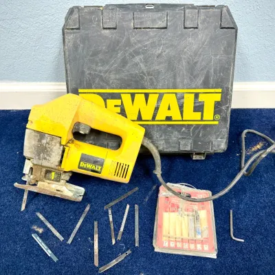 Sale Photo Thumbnail #599: DeWalt corded jigsaw with black hard plastic carrying case, assorted blades, and hex key.