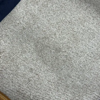Sale Photo Thumbnail #702: Close-up of a neutral beige tweed upholstered chair seat showing light staining and wear.