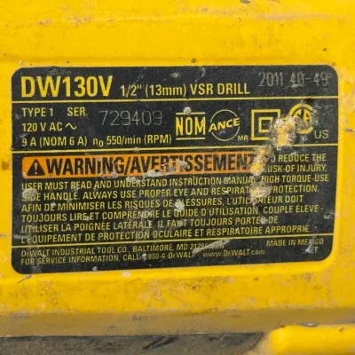 Sale Photo Thumbnail #614: Close-up of the specification label on a DeWalt DW130V 1/2-inch VSR corded electric drill, showing model details, serial number, and safety warnings.