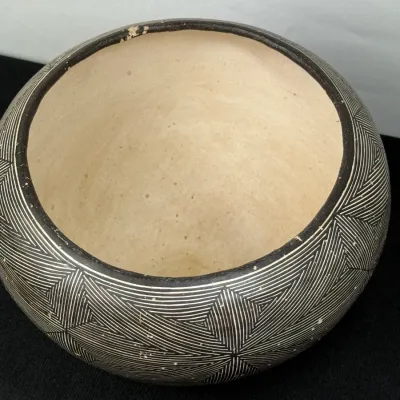 Sale Photo Thumbnail #132: Handcrafted Native American style pottery bowl featuring a fine black-and-white geometric fine-line pattern around the exterior with a plain cream interior and minor rim wear.
