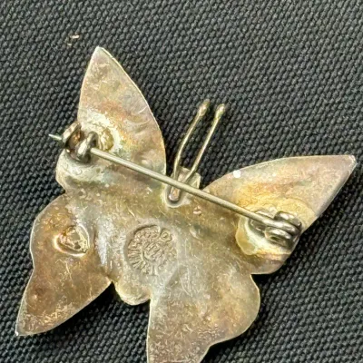 Sale Photo Thumbnail #188: Vintage Mexican sterling silver butterfly brooch featuring a pin mechanism and Maker's hallmark stamps on the back.