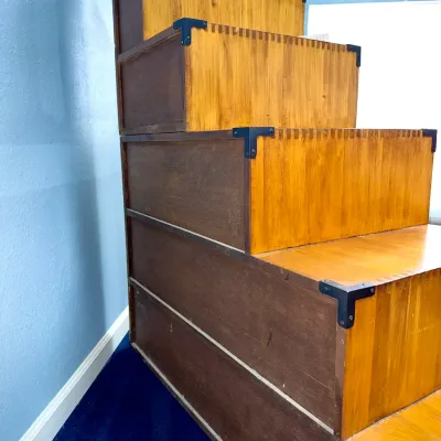 Sale Photo Thumbnail #217: Japanese tansu-style step chest with dark metal corner brackets and finger-joint construction.