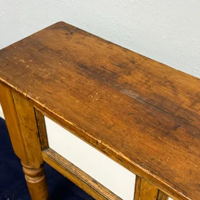 Sale Photo Thumbnail #281: Rustic wooden console table featuring turned legs and a distressed natural finish showing significant surface wear and patina.