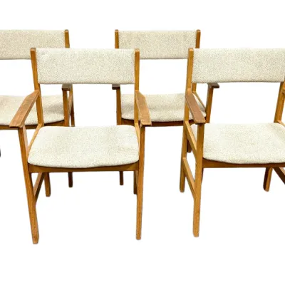 Sale Photo Thumbnail #63: Set of four Danish modern teak armchairs with light beige tweed upholstery, showing light finish wear on the wooden armrests.