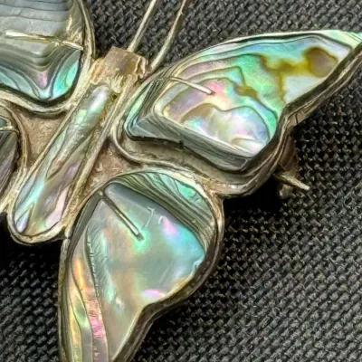 Sale Photo Thumbnail #187: Vintage abalone shell and sterling silver butterfly brooch featuring iridescent inlay details.