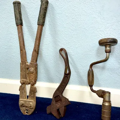 Sale Photo Thumbnail #562: Trio of vintage hand tools including a Nicopress crimping tool, a rusted offset adjustable wrench, and a hand brace drill.