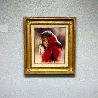Sale Photo Thumbnail #149: Framed oil painting depicting a Native American figure wrapped in a red blanket, set in an ornate gilded frame with a linen liner.