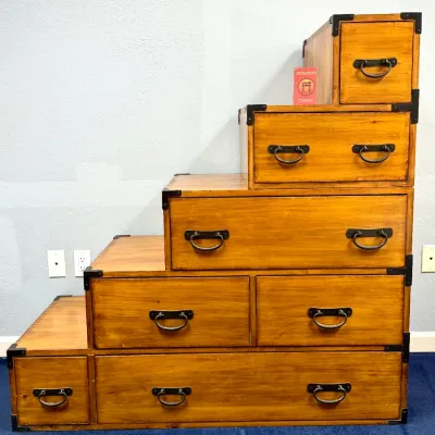 Sale Photo Thumbnail #201: Japanese Kaidan Tansu step chest crafted from light honey-finished wood, featuring iron corner brackets and bail handles on multiple drawers.