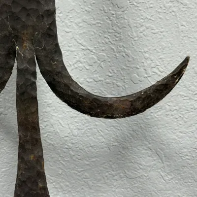 Sale Photo Thumbnail #643: Hand-hammered wrought iron detail showing a textured, curved metal motif with an aged dark patina.