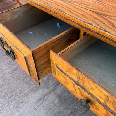 Sale Photo Thumbnail #259: Open drawers of a vintage oak desk or console, showcasing wood grain finishes and period metal hardware.