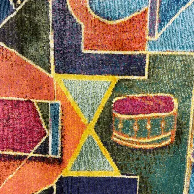 Sale Photo Thumbnail #726: Close-up of a modern geometric area rug featuring bold shapes and vibrant colors including blue, orange, magenta, and green.