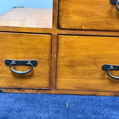 Sale Photo Thumbnail #209: Japanese tansu-style step chest with warm wood finish, decorative metal corner brackets, and iron drop-handle hardware.