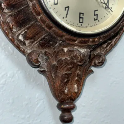 Sale Photo Thumbnail #396: Vintage New Haven Clock Co. 12-day wall clock featuring an ornate carved wood or molded frame with acanthus leaf details.
