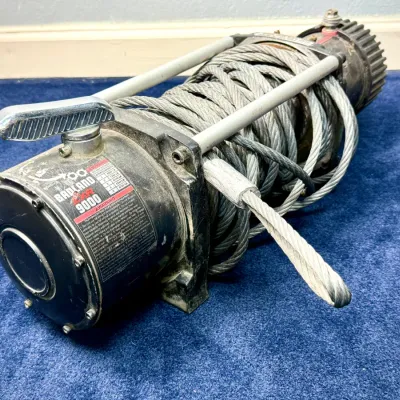 Sale Photo Thumbnail #665: Badland ZXR 9000-lb electric winch wrapped with heavy-duty steel wire cable, showing light exterior wear.