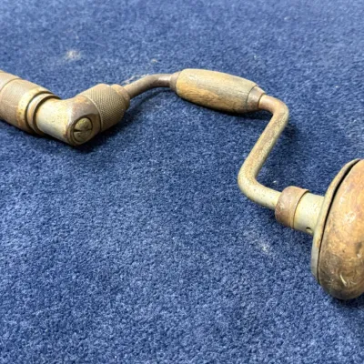 Sale Photo Thumbnail #565: Vintage hand brace drill featuring wooden handles and a metal frame with patina from age and use.