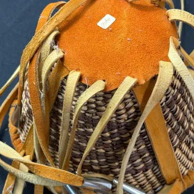 Sale Photo Thumbnail #409: Hand-woven Native American style basket featuring a suede leather base cover with fringe and metal cone tinklers.