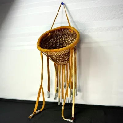 Sale Photo Thumbnail #29: Native American style woven wall basket featuring leather trim, long suede fringe, and metal tin cone accents.