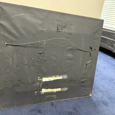 Sale Photo Thumbnail #452: Back of a framed artwork featuring black dust paper, a hanging wire, and some tape, displaying age-related wear.