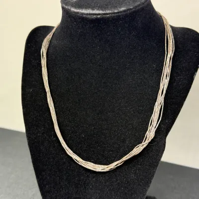 Sale Photo Thumbnail #177: Multi-strand liquid silver necklace displayed on a black velvet jewelry bust.