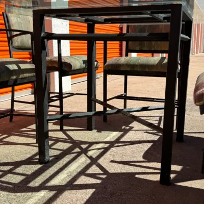 Sale Photo Thumbnail #293: Black metal glass-top patio or dining table with four matching upholstered chairs.