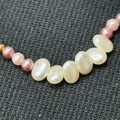 Sale Photo Thumbnail #195: Multicolor freshwater pearl necklace featuring white oval pearls paired with pink spherical pearls and gold spacer beads.