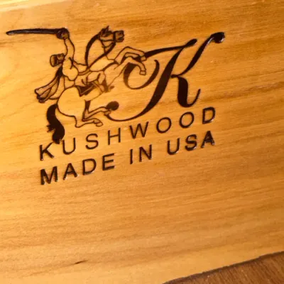 Sale Photo Thumbnail #719: Maker's mark for Kushwood furniture stamped onto wood, featuring a horse-and-rider logo and "Made in USA" text.