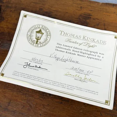 Sale Photo Thumbnail #818: Thomas Kinkade Certificate of Authenticity for a hand-highlighted limited edition lithograph titled "Village Lighthouse," dated 2003.
