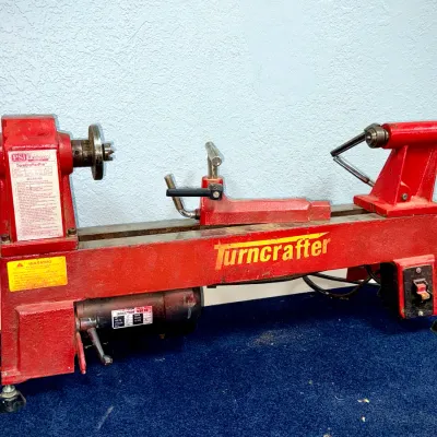 Sale Photo Thumbnail #46: PSI Woodworking Turncrafter Pro red mini wood lathe with induction motor, showing light wear from use.